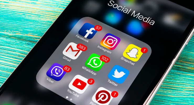 Un écran de mobile affiche une liste d’applications mobiles Facebook, Whats’app, Twitter, Snapchat, Instagram…