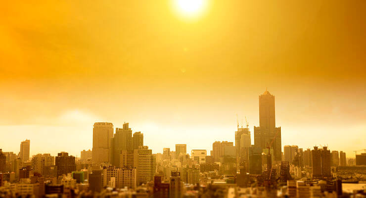 Une grande ville est surplombée par un soleil de plomb sous un nuage de pollution