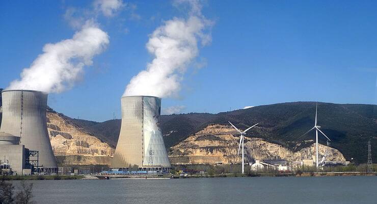 Des cheminées de centrales nucléaires aux côtés d’éoliennes