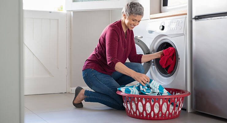 Une femme remplit son lave-linge