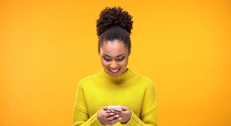 Femme souriante sur son téléphone portable