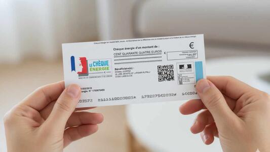 chèque énergie tenu entre mains